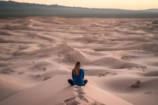 vrouw zit in de woestijn